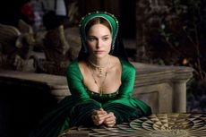 Natalie Portman as Anne Boleyn in a green Tudor style dress and headband and gold 'B' necklace with pearl drops