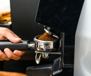 An automatic coffee grinder grinding coffee into a portafilter