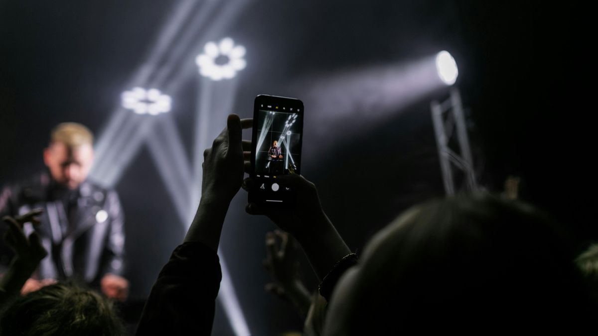 Taking a photo with a smartphone at a concert