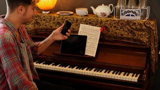 Man at piano with phone and tablet