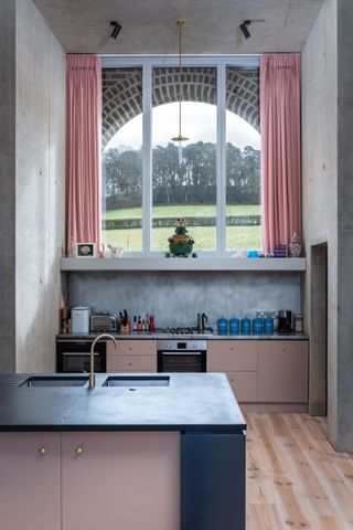 Pink kitchen with large window and pink curtains