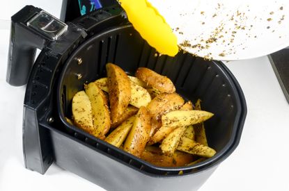 Homemade potato wedges cooking in an air fryer