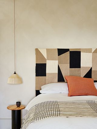 Beige bedroom with a geometric patterned fabic headboard