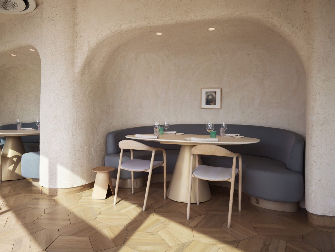 A drenched-in-neutrals restaurant features sculptural textured walls and furniture.