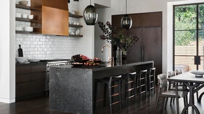 Black kitchen with black waterfall island countertop