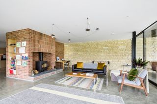 living room with woodburning stove with brick and stone walls