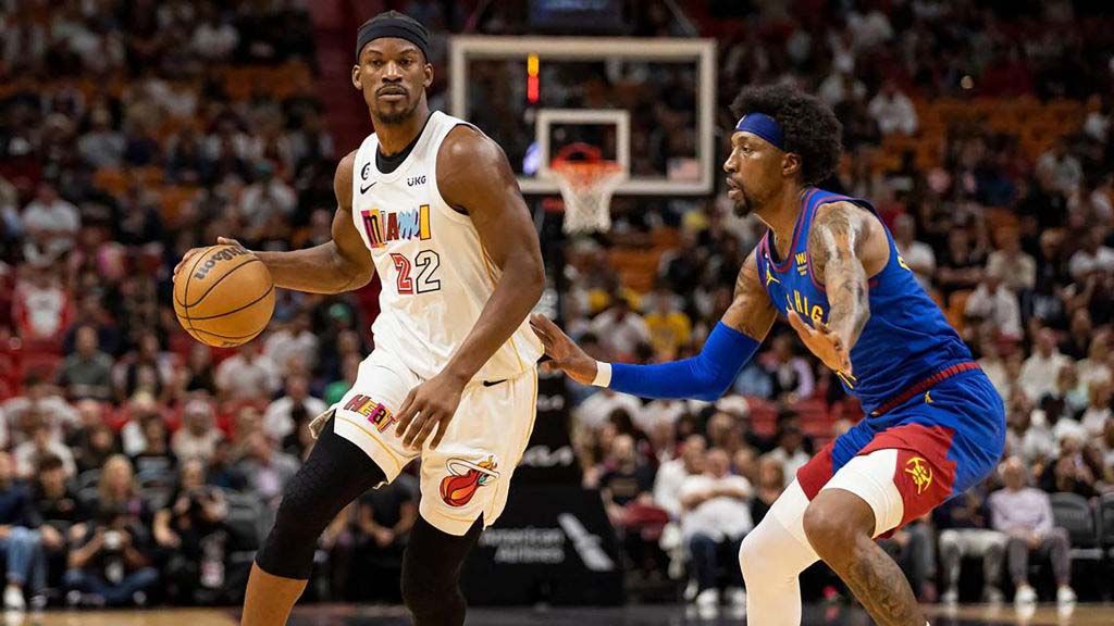 Miami Heat forward Jimmy Butler dribbles while Denver Nuggets guard Kentavious Caldwell-Pope defends during the first quarter of an NBA game at Kaseya Center on Monday, Feb. 13, 2023