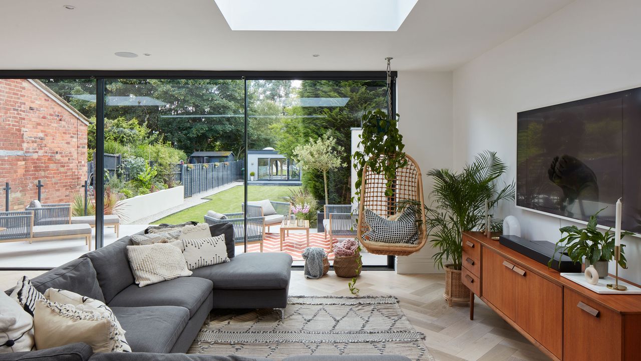 Living area in extended room with grey corner sofa