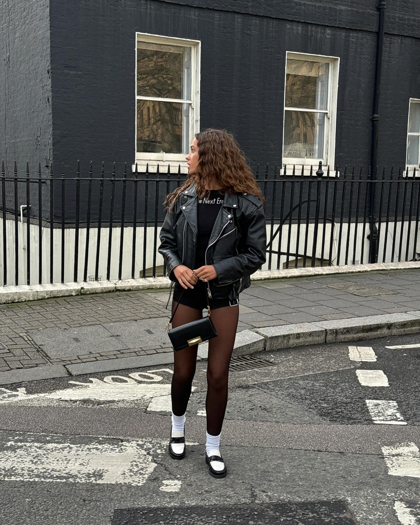 Fashion person Sarah Lysander wears the indie sleaze trend 2026. She wears a leather biker jacket.