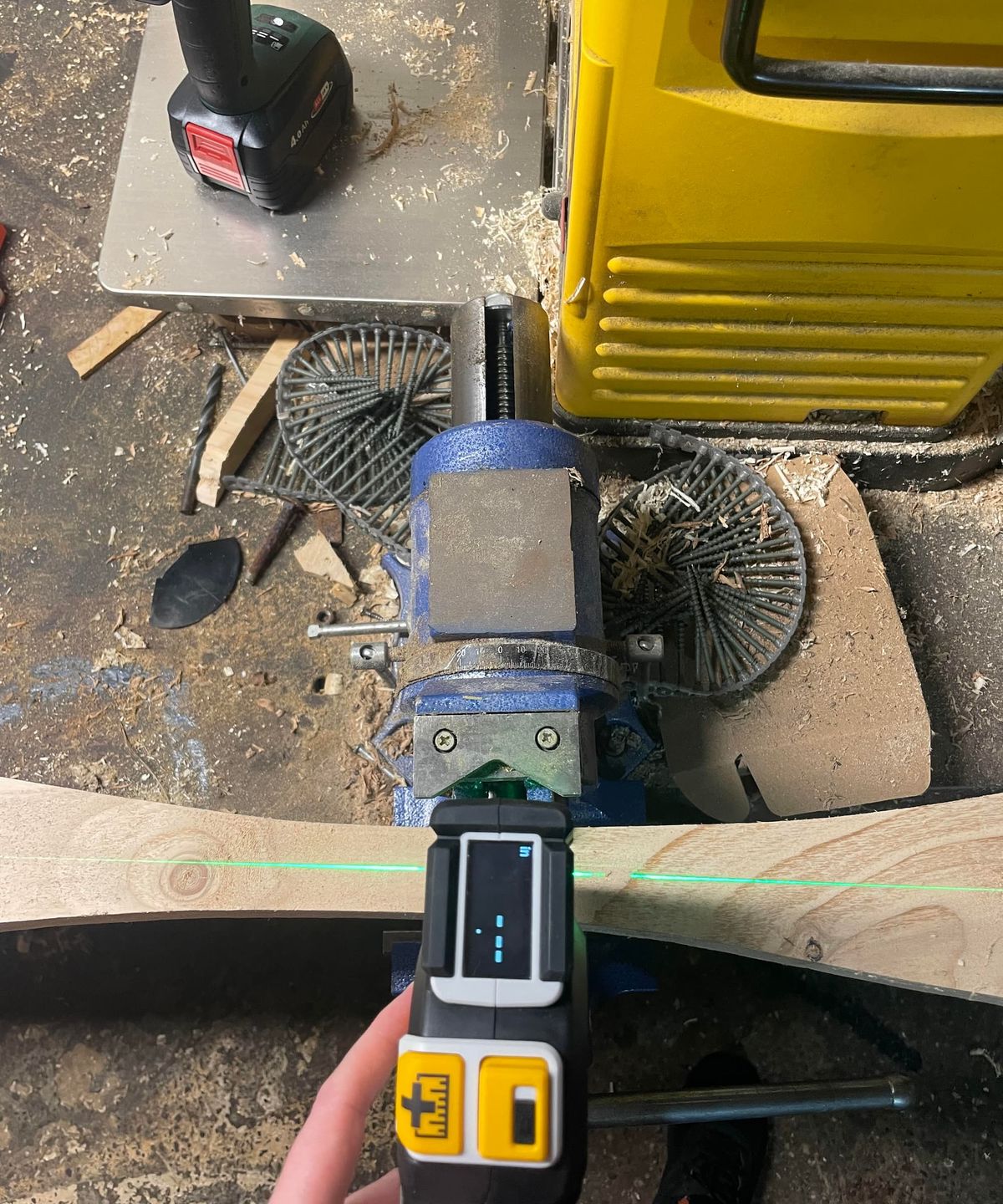 A laser tape measure seen from above on a block of wood