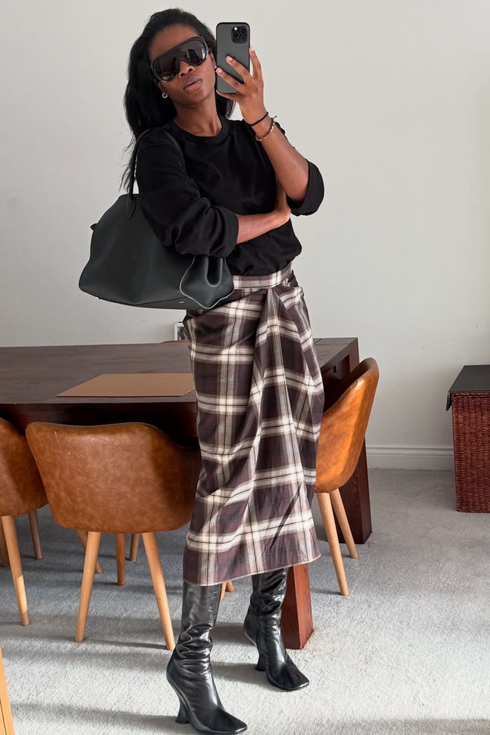 Anti-flat shoes trends winter 2025 @nlmarilyn wearing a black jumper, checked midi skirt and knee high black sock boots