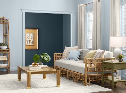 A living room with light blue walls and rattan furniture 