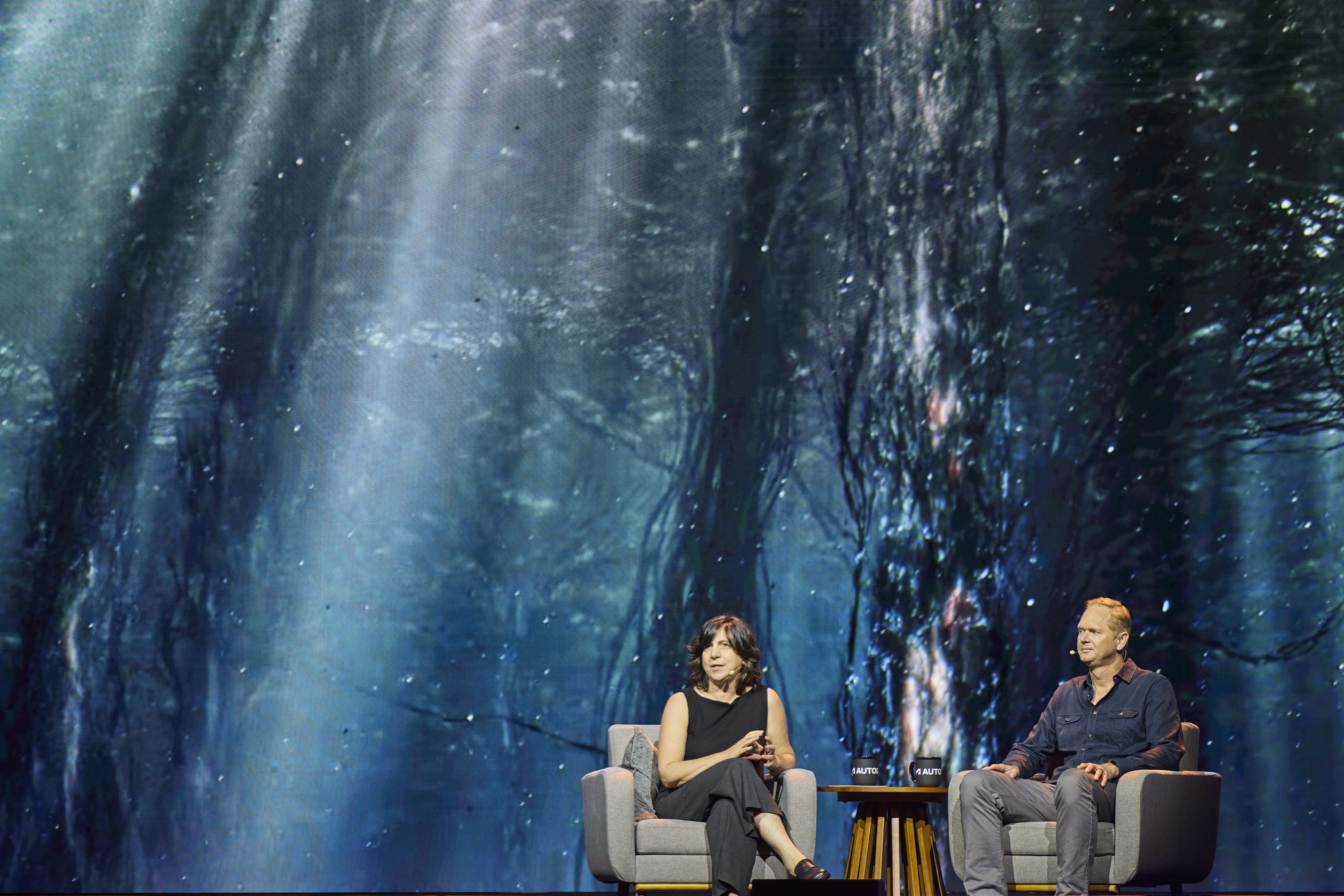 AU 2025; two people sit on a stage and chat