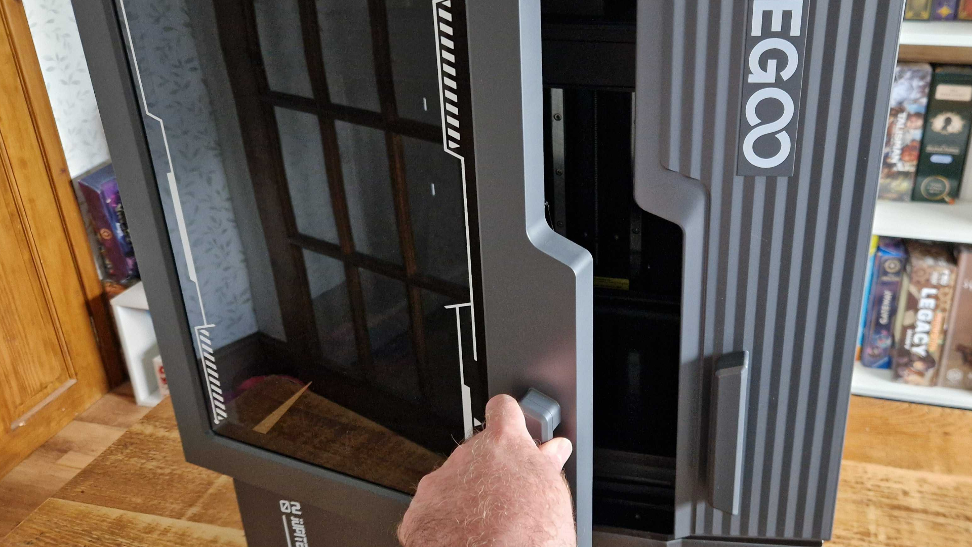 A hand opens the door of the Elegoo Jupiter 2