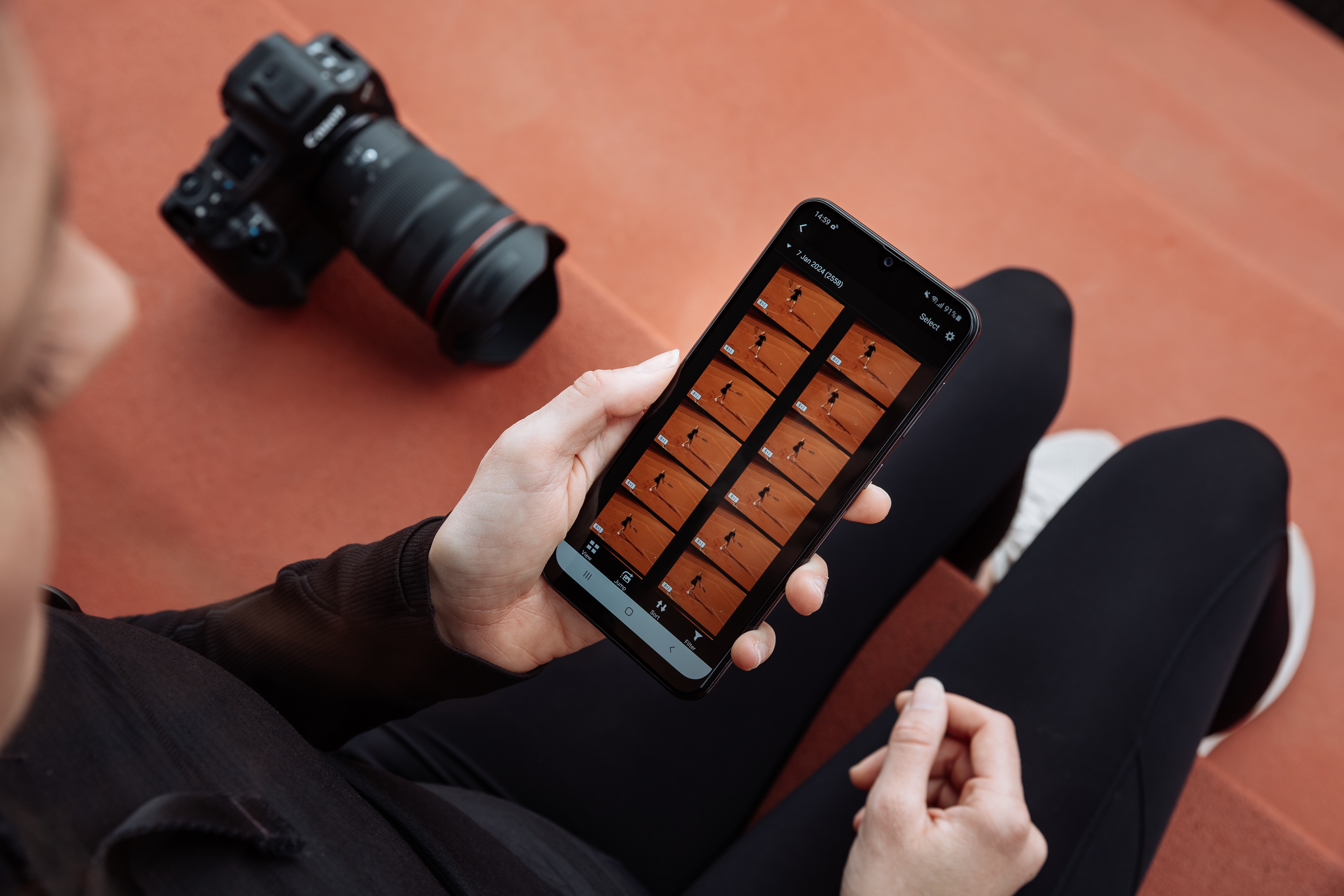 A person holding a phone showing photos taken by the Canon EOS R1 camera