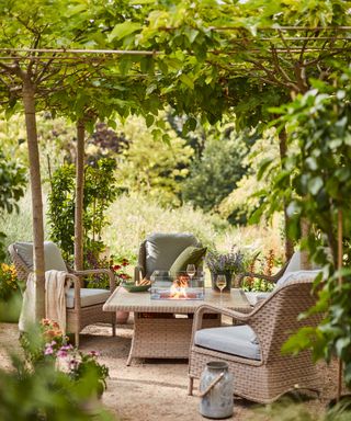 A contemporary outdoor setting with firepit table and matching synthetic wicker weave chairs