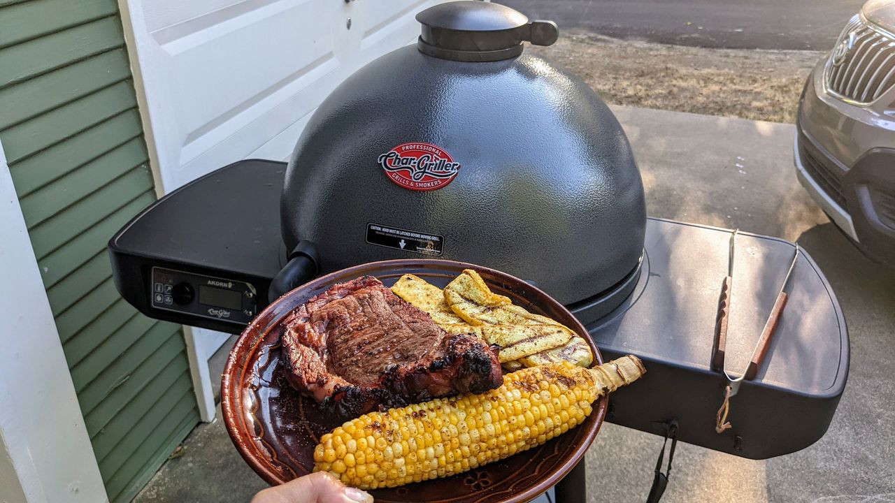 plate of grilled food in front of the AKORN Auto-Kamado grill