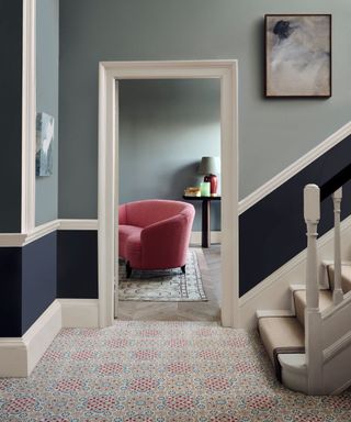 hallway with patterned carpet and wall painted in two sections with dark on bottom and light on top