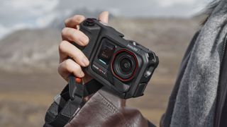 Insta360 Ace Pro 2 action camera housed inside grip accessory, in user's hand