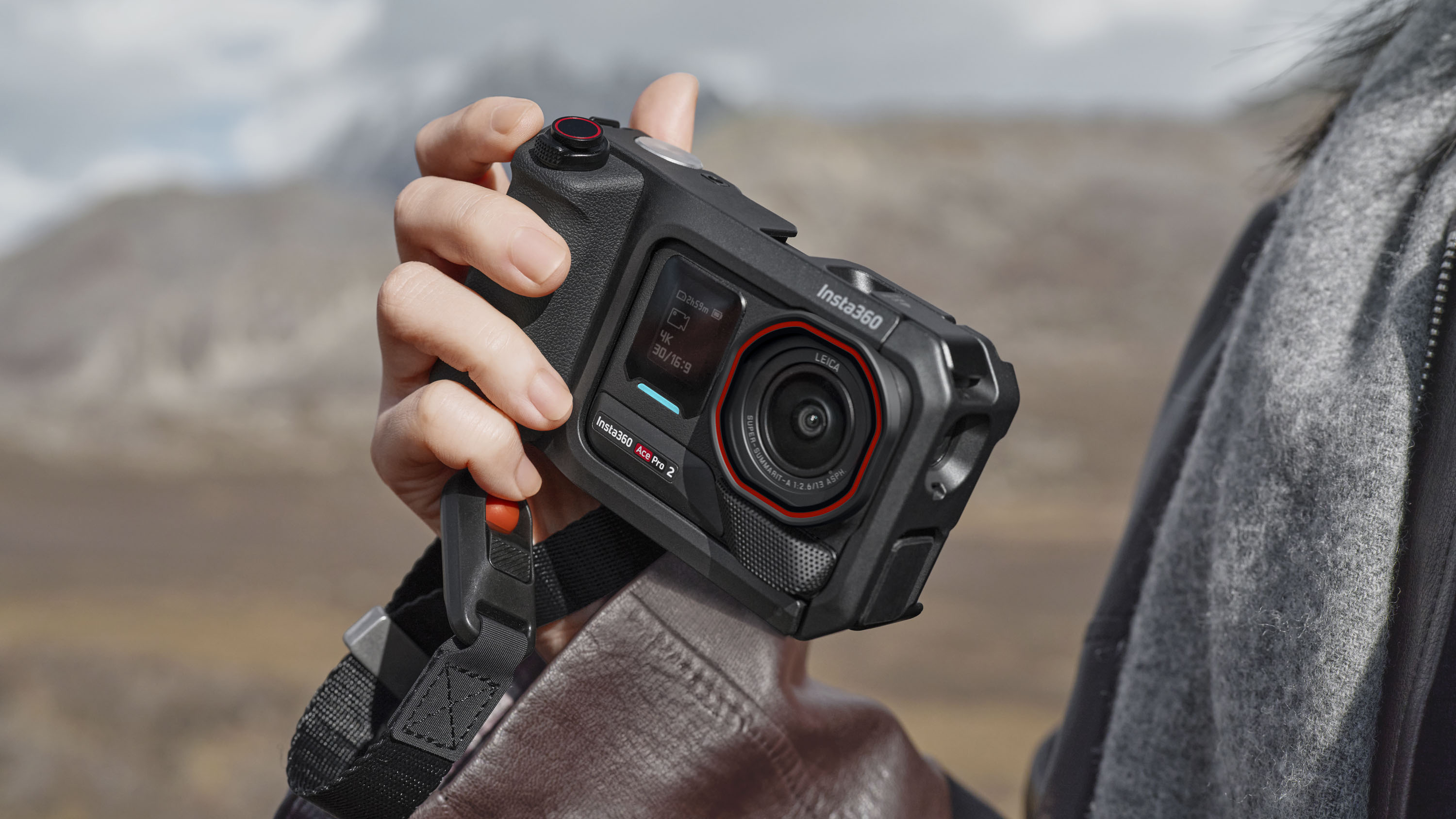 Insta360 Ace Pro 2 action camera housed inside grip accessory, in user&#039;s hand