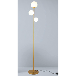 slim gold floor lamp with three large light orbs near the top of the stem