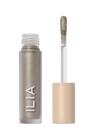 A sage green ILIA liquid eyeshadow set against a white background.