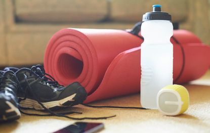 Yoga mat, water bottle and running shoes