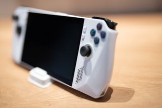 A white ASUS ROG Ally handheld games console on a wooden desk