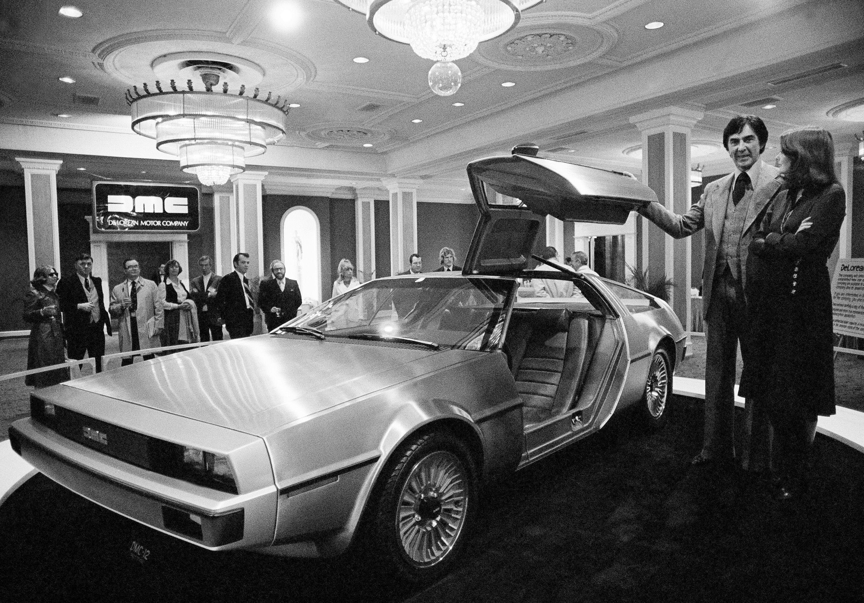 2NFEEBY John Z. Delorean and his wife Christina, of Detroit, stand by his prototype car, Model 12, that was unveiled in New Orleans, La., Jan. 31, 1977. The brushed steel and fiber glass sports car is scheduled for production in 1979 with a six-cylinder engine, reported to get 30 miles per gallon on the highway. The cost: around $10,000. (AP Photo/Jack Thornell)