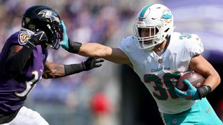 Alec Ingold (R) hands off Chuck Clark (L) ahead of the Dolphins vs Ravens live stream