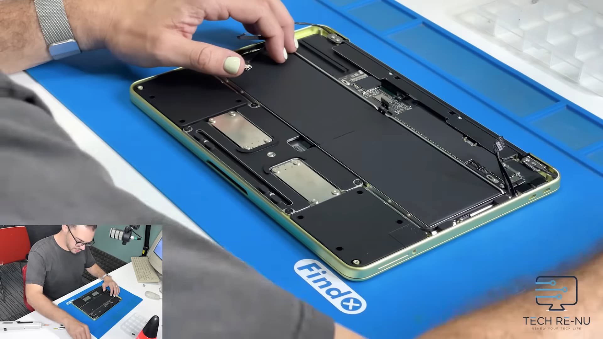 A person from repair company Tech Re-Nu tearing down an Apple MacBook Neo laptop.