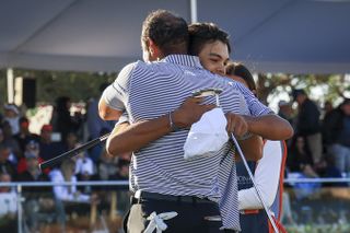 Tiger and Charlie Woods hug on the 18th green at the PNC Championship