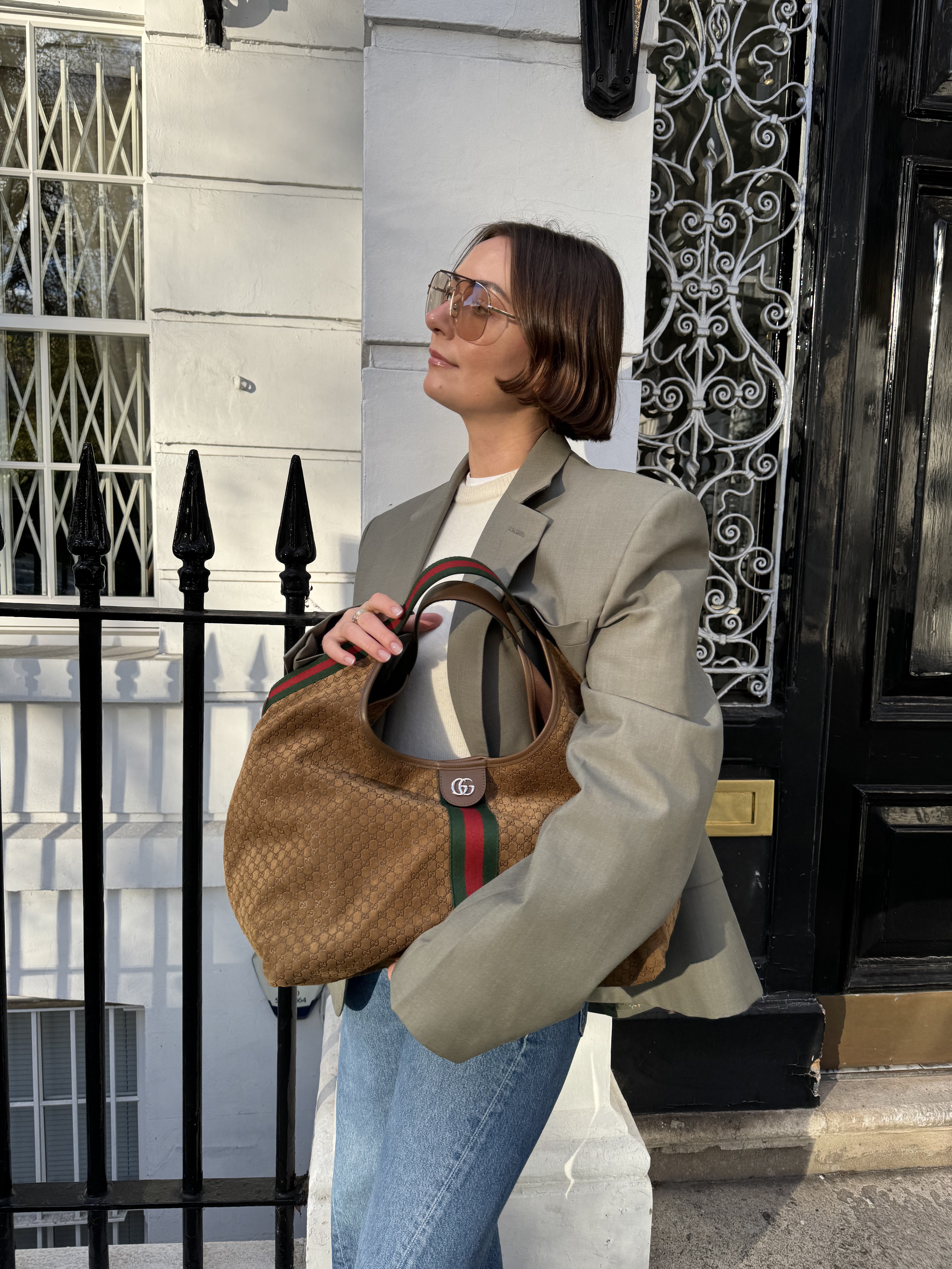 Sophie wears a blazer, blue jeans and carries the Gucci Giglio bag