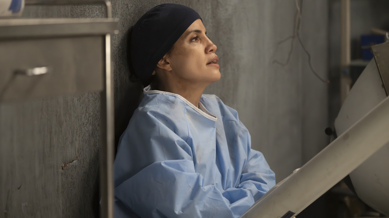 Monica Beltran (Natalie Morales) is pinned under a surgical lamp that fell on her during an explosion in the Grey&#039;s Anatomy Season 22 premiere on October 9, 2025.