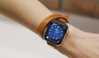 An Apple Watch 6 on a person's arm with a brown leather strap