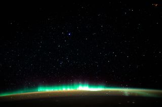 A vibrant, green aurora lights up Earth's upper atmosphere in this photo captured by an astronaut at the International Space Station. When this photo was taken on Jan. 22, the station was orbiting 261 miles (420 kilometers) above the Atlantic Ocean off the coast of North America. Beneath the northern lights is a blanket of marmalade-colored airglow, a type of luminescence caused by ultraviolet light that triggers chemical reactions high in Earth's atmosphere. Auroras, on the other hand, are created when charged particles from the sun ionize or excite particles in the atmosphere.