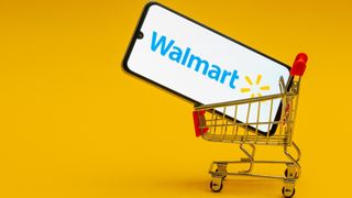 Mini cart holding smartphone with Walmart logo on screen