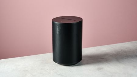 The Sonos Era 100 SL at a 3/4s angle in front of a pink background.