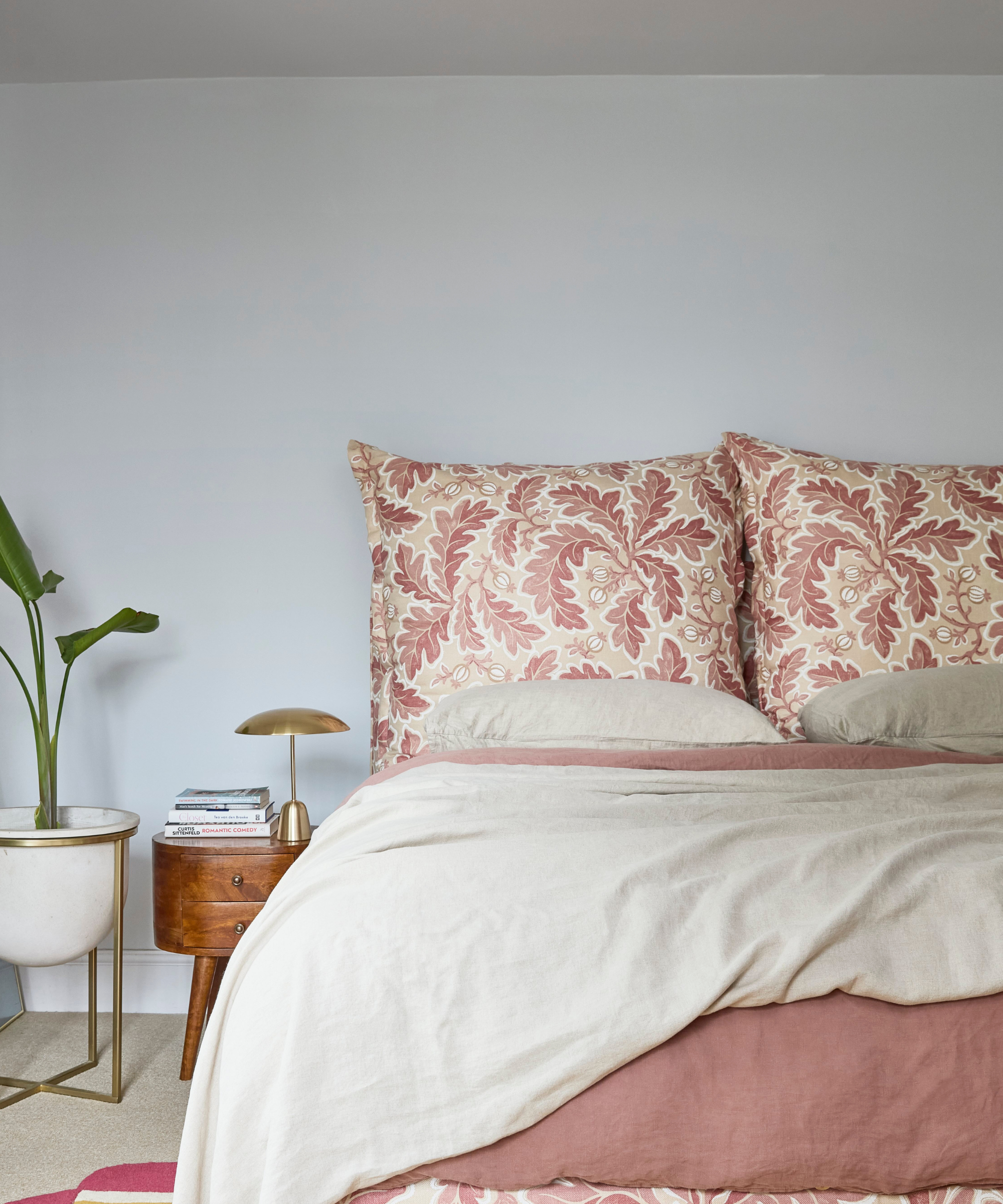 Pink floral dual pillow headboard on bed