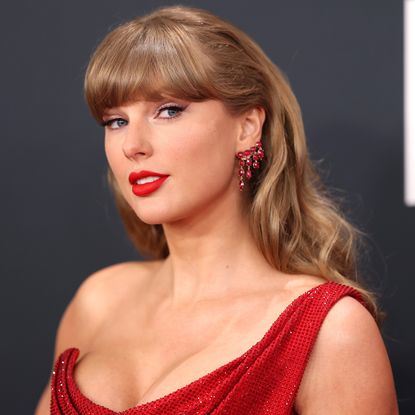 taylor Swift arrives at the 2025 Grammy awards in a bright red mini dress