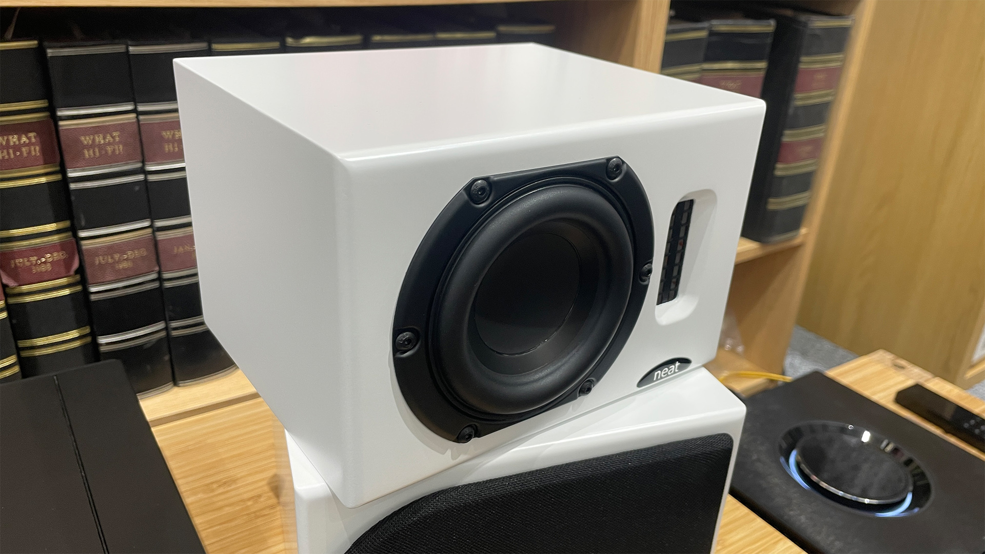 Neat Iota II speakers in white finish placed on wooden shelf