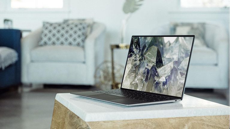 Best Dell laptops hero image showing XPS 13 open in living room