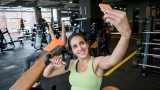 A woman takes a selfie at the gym