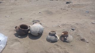 A selection of pots sitting in sand