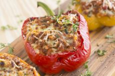 Close up of red Bolognese stuffed peppers on a board