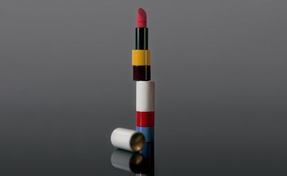 Two lipsticks stacked on top of each other against a shaded background
