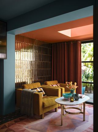 A living room with yellow sofas and pink ceiling and curtains