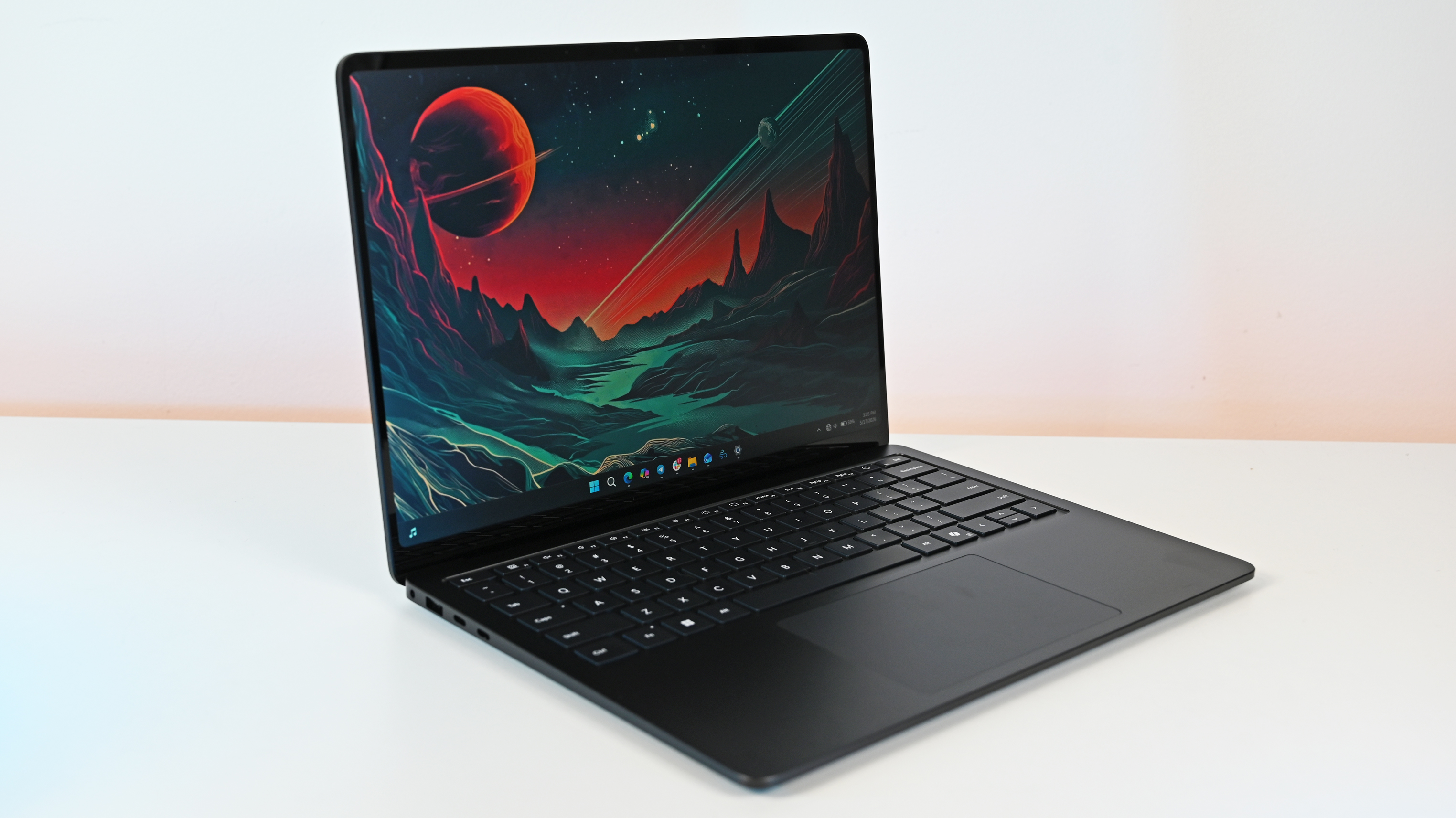 Surface Laptop for Business 8th Edition sits open on a white surface, displaying a vibrant sci-fi landscape wallpaper with a red planet and mountainous terrain.