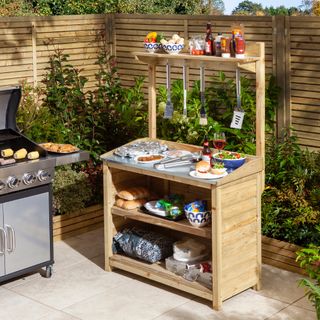 outdoor kitchen storage unit with zinc worktop, hanging hooks, two shelves, BBQ to left