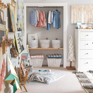 Open wardrobe in a kids bedroom with hanging space and baskets